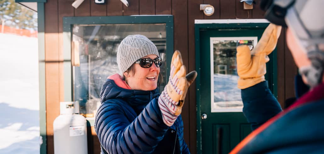 Female Lift attendant give high five as lift loads